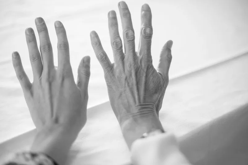 Mãos de uma mulher mais velha e de uma mulher mais jovem lado a lado